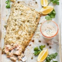 Salmon filet with lemon caper sauce on top and on the side