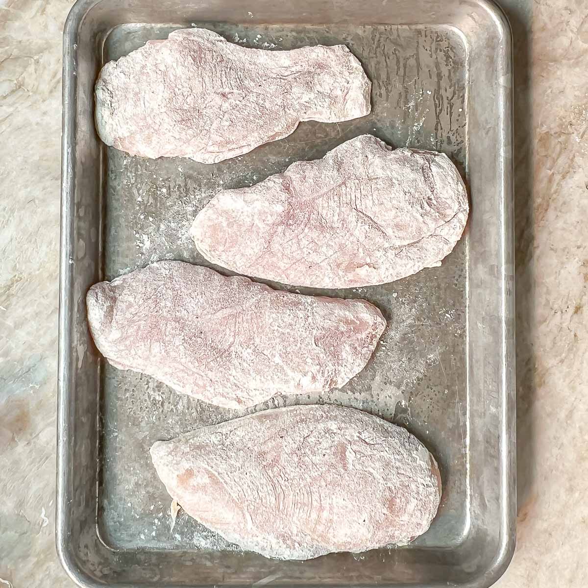 4 dredged breasts on a small sheet pan