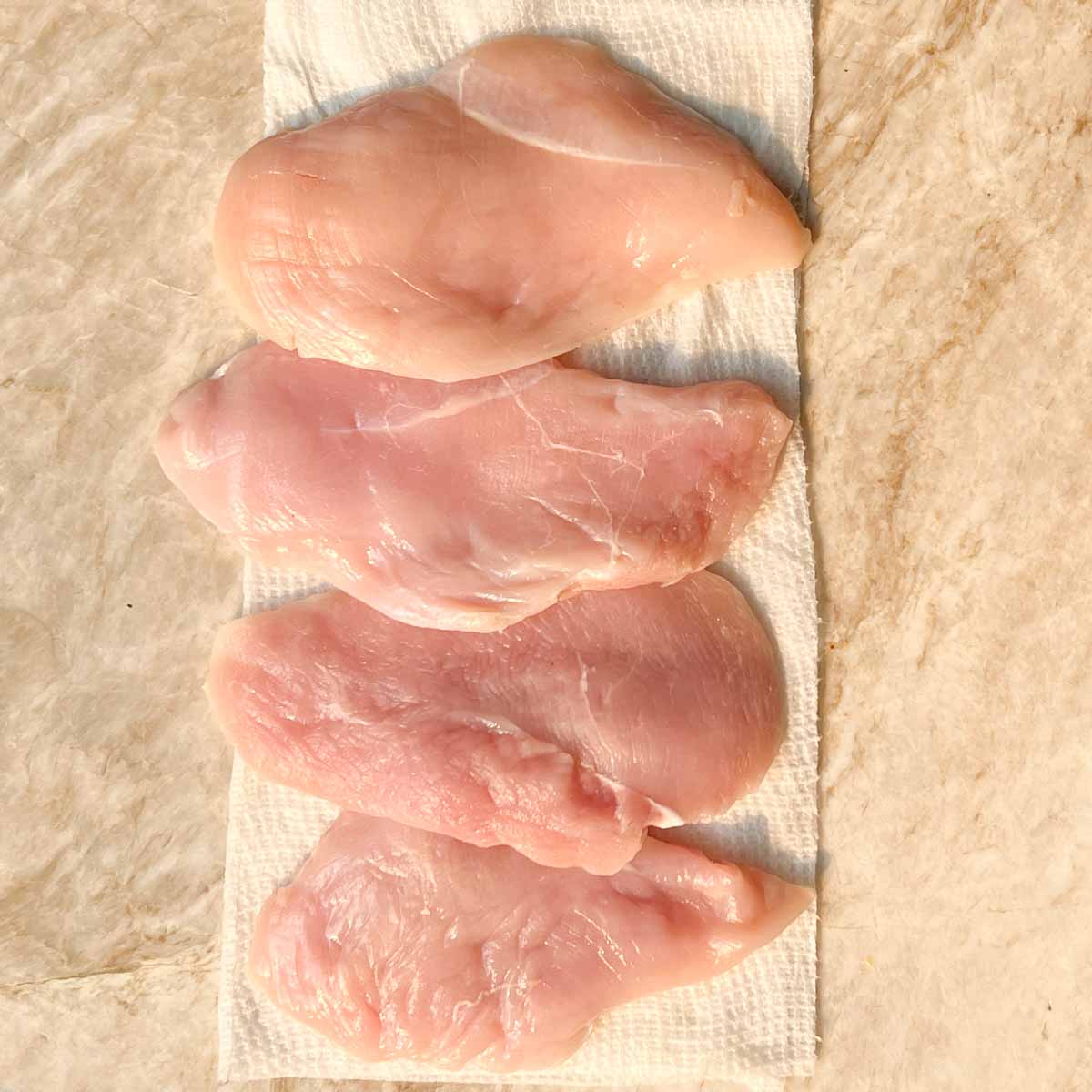 4 chicken breasts drying on paper towels