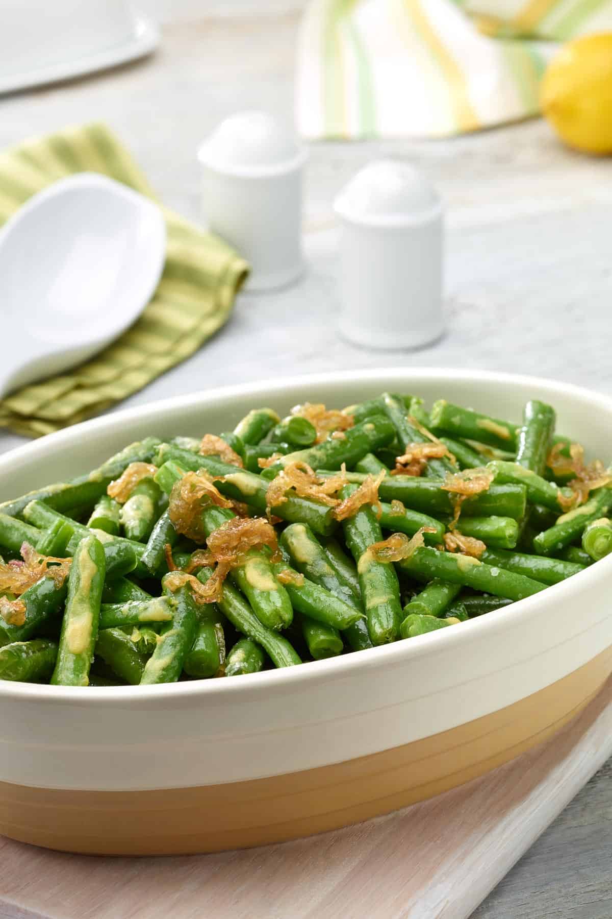 Oval white dish filled with Lemon-Dijon Green Beans with Caramelized Shallots