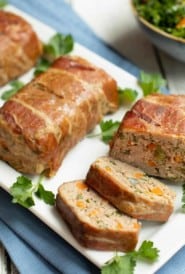 Mini Meatloaves Wrapped In Prosciutto, one sliced, on a white platter