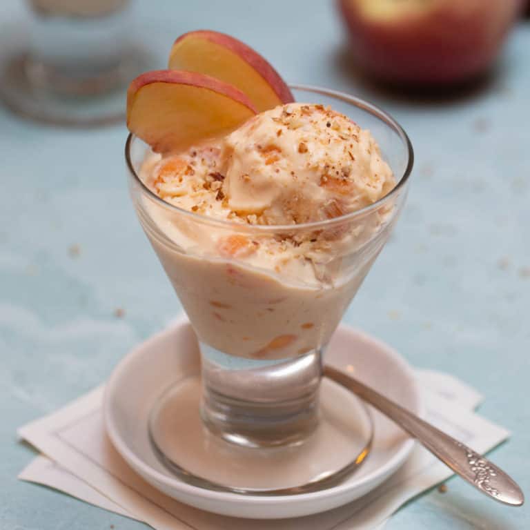 glass sherbet bowl filled with scoops of Peach Ice Cream