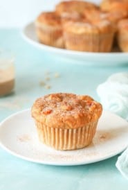 single Peach Muffin on a plate wtih a platter holding more muffins in back