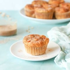 single Peach Muffin on a plate wtih a platter holding more muffins in back