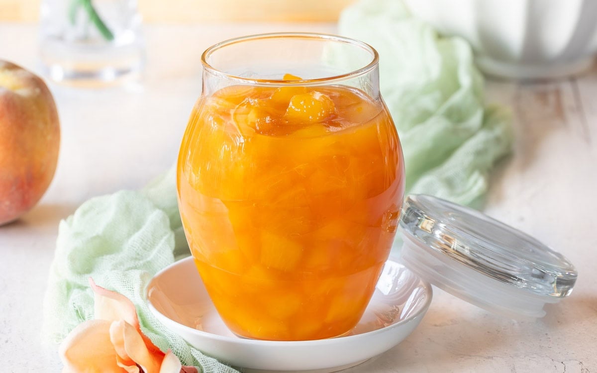 Close up of a glass jar holding Peach Sauce