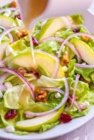Pear and Goat Cheese Salad with Walnut Vinaigrette pouring out of a white pitcher