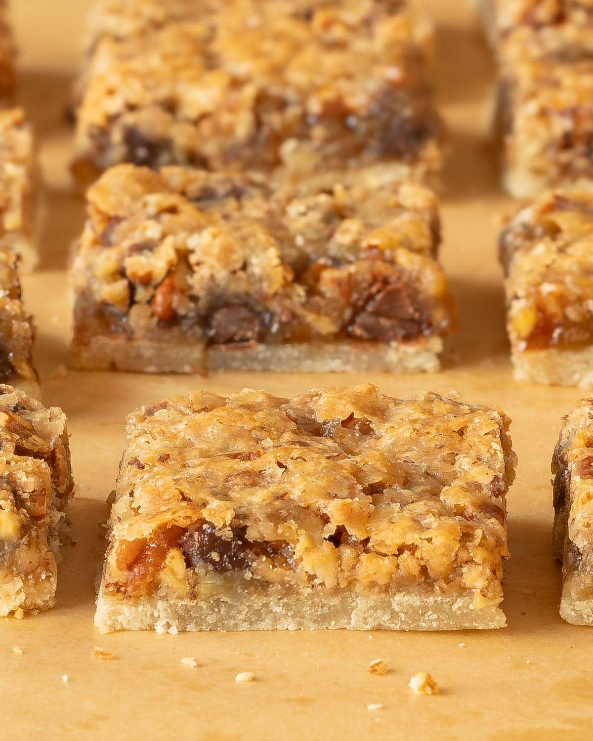 Pecan Pie Bars cut into individual bars on a wooden board, showing the inside of the cookie