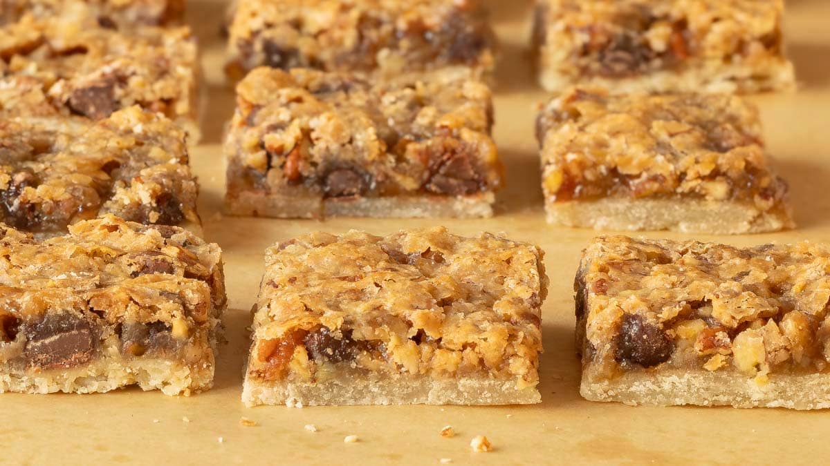 Pecan Pie Bars cut into individual bars on a wooden board, showing the inside of the cookie