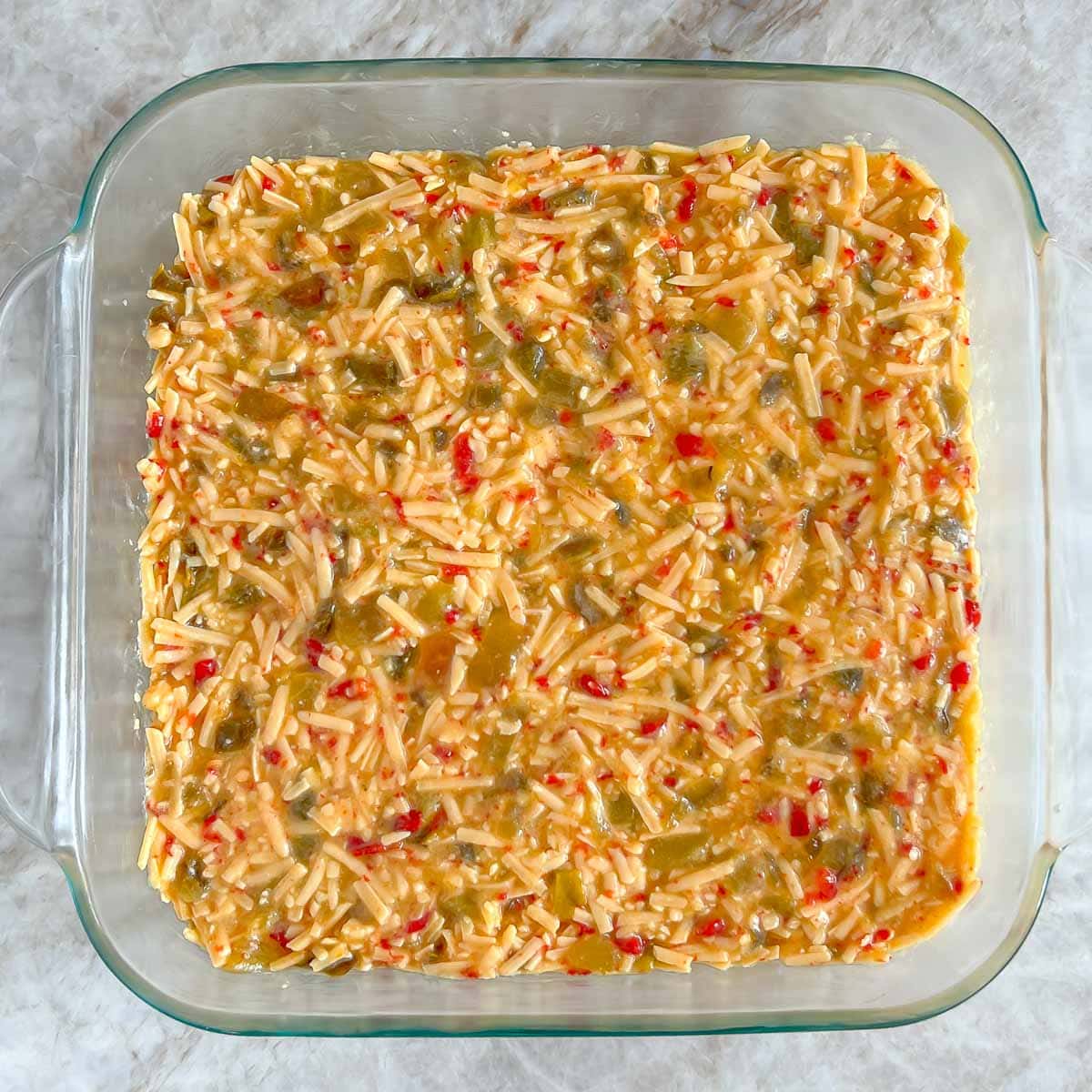 8 by 8 inch baking dish filled with the cheese mixture, showing the smooth top