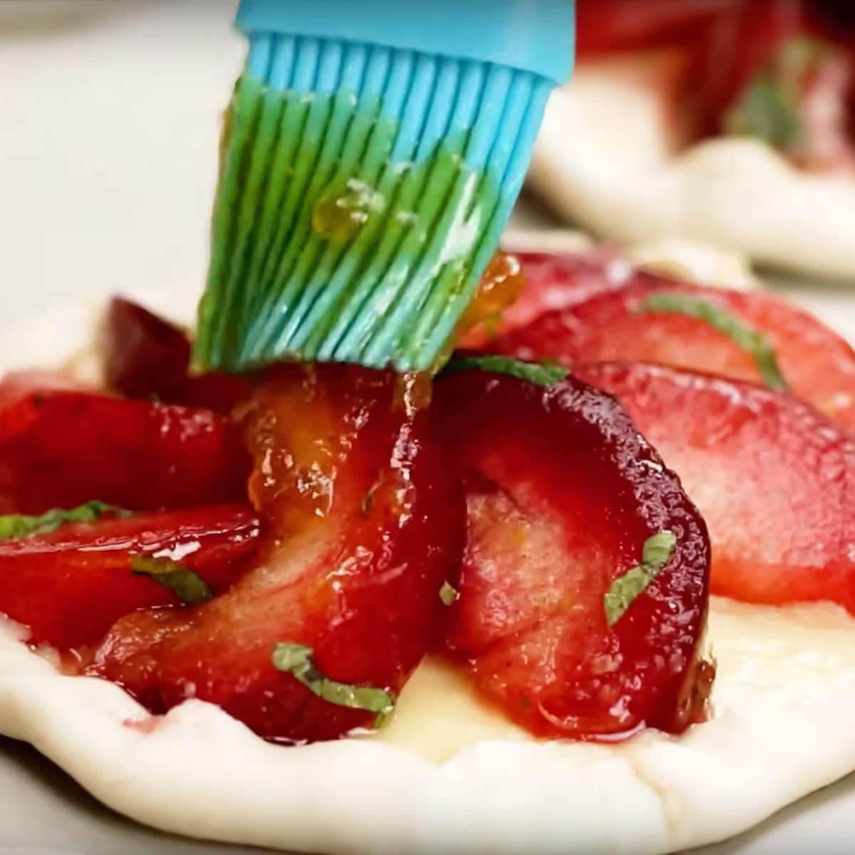 process shot brushing tops of tarts with warm apricot jam