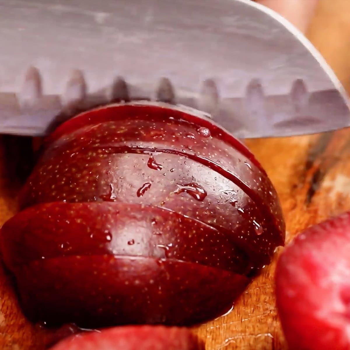 process shot slicing a plum, showing width of slices