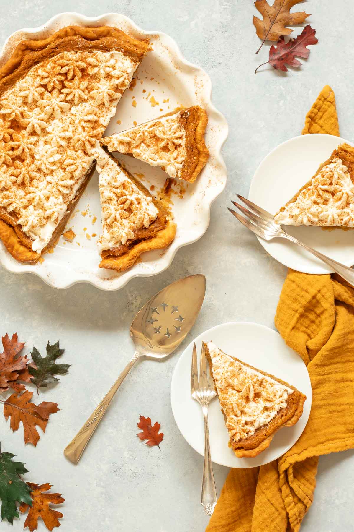Overhead view of Pumpkin Chiffon Pie in pie plate, with two cut pieces in plate and 2 more pieces on individual plates