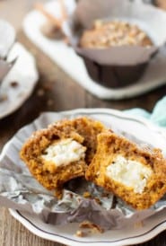 Pumpkin muffins, one broken half to show cream cheese filling