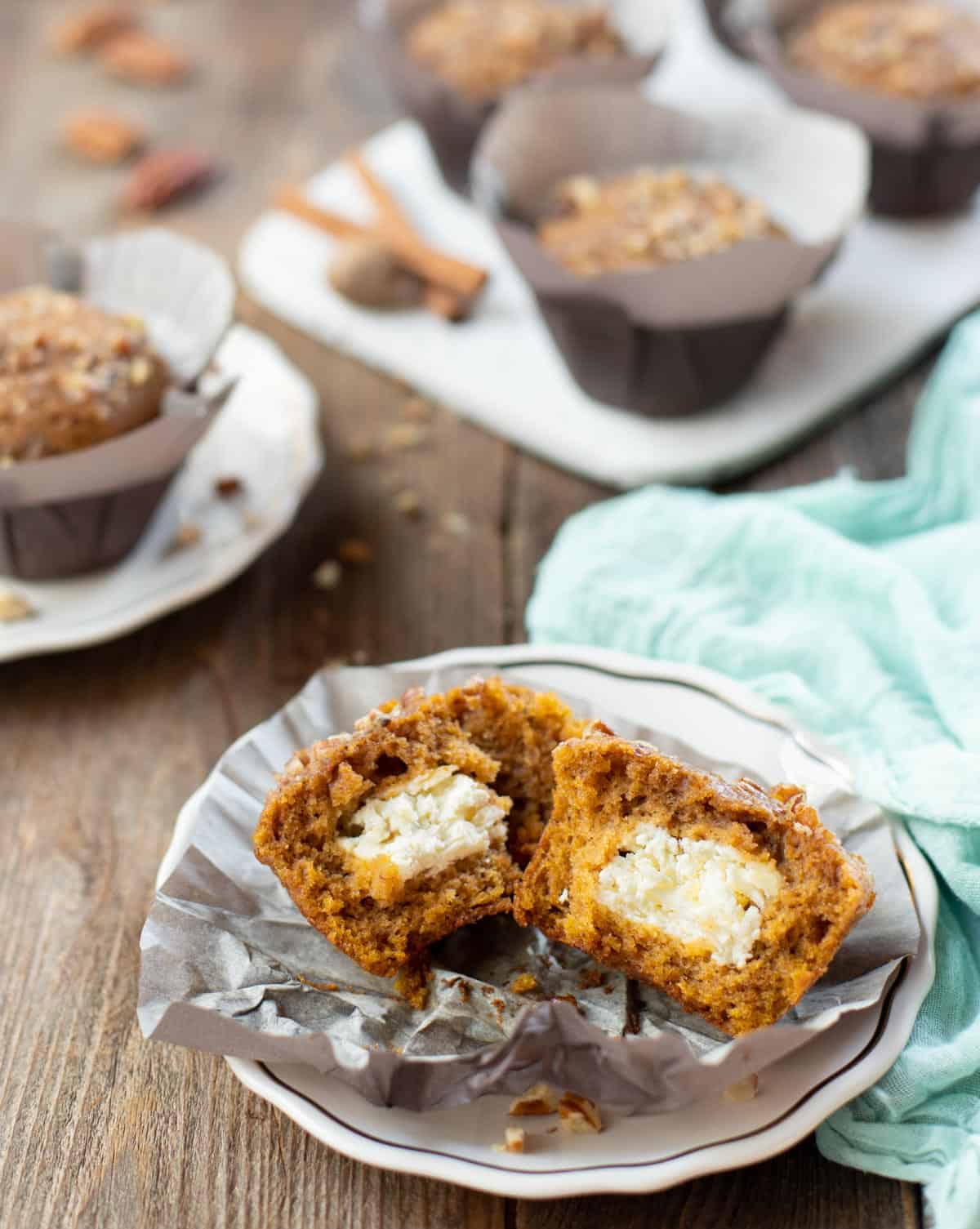 Pumpkin Cream Cheese Muffins, one broken in half showing cream cheese filling