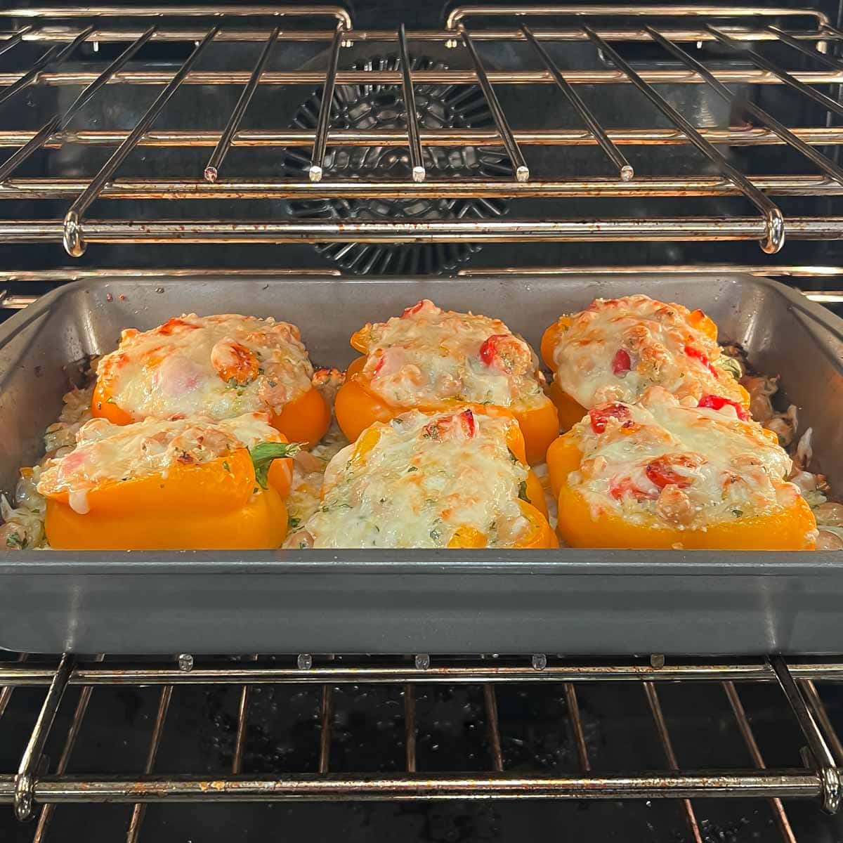 Quinoa stuffed bell peppers baking in oven, almost ready