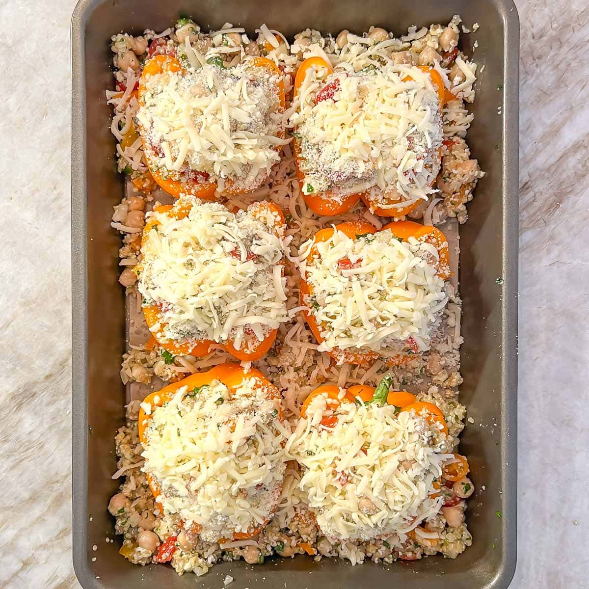 Stuffed bell peppers with cheese on top ready for baking