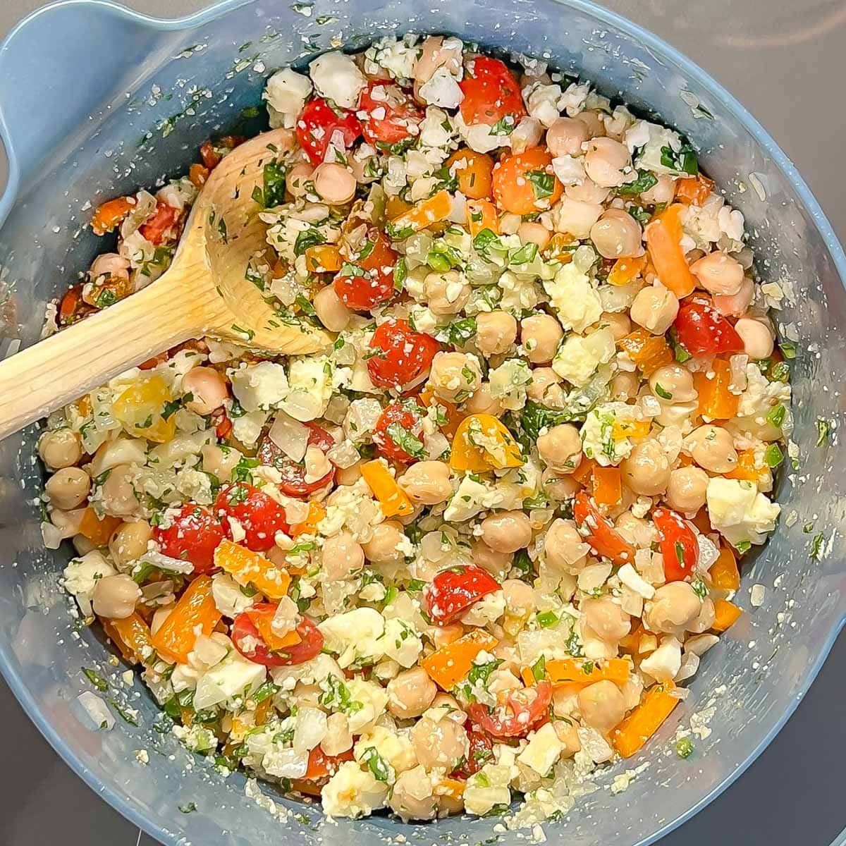 Process shot of quinoa stuffing in a a blue bowl, after all ingredients have been added