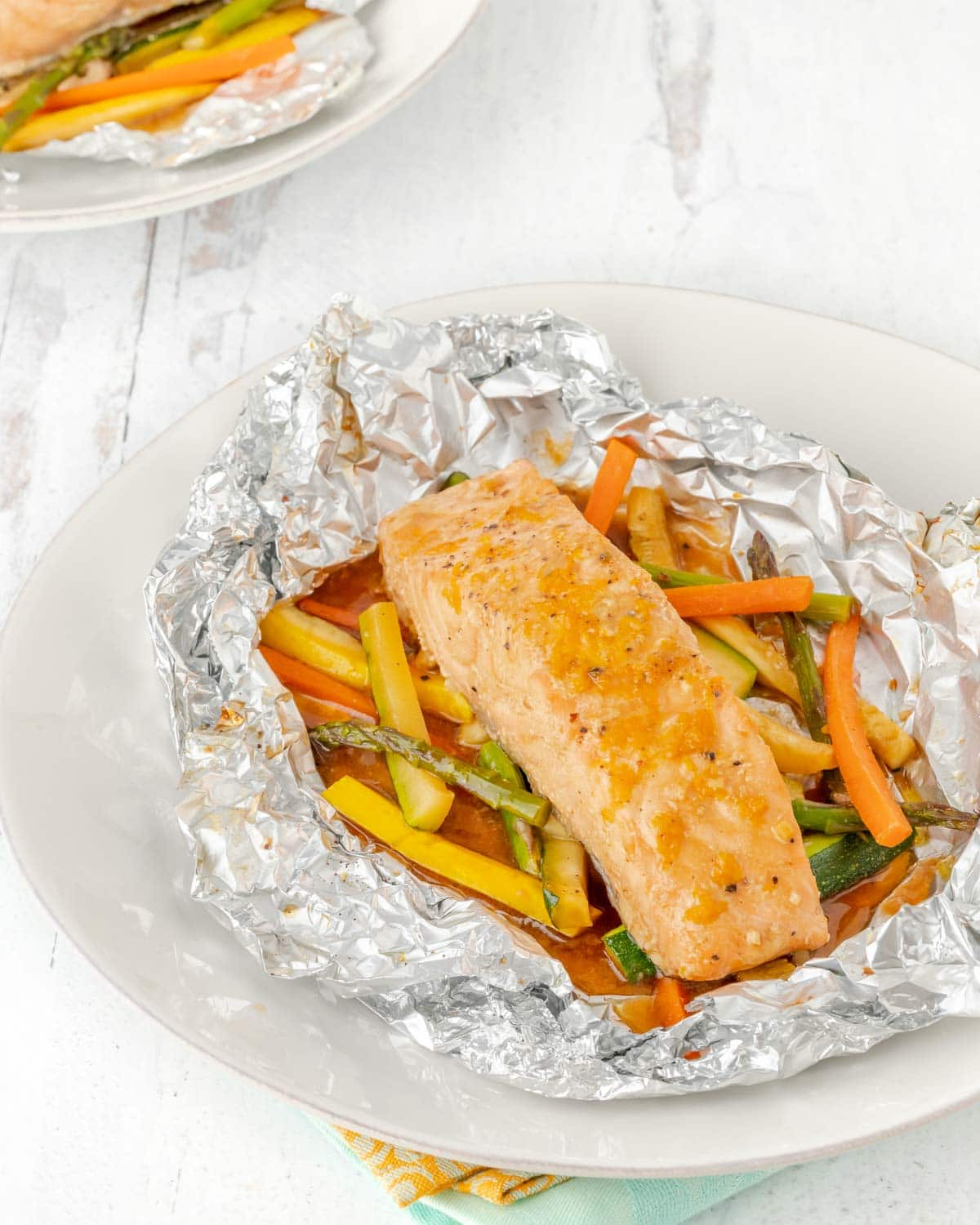 Salmon and vegetables baked in foil, with foil cut open to show inside