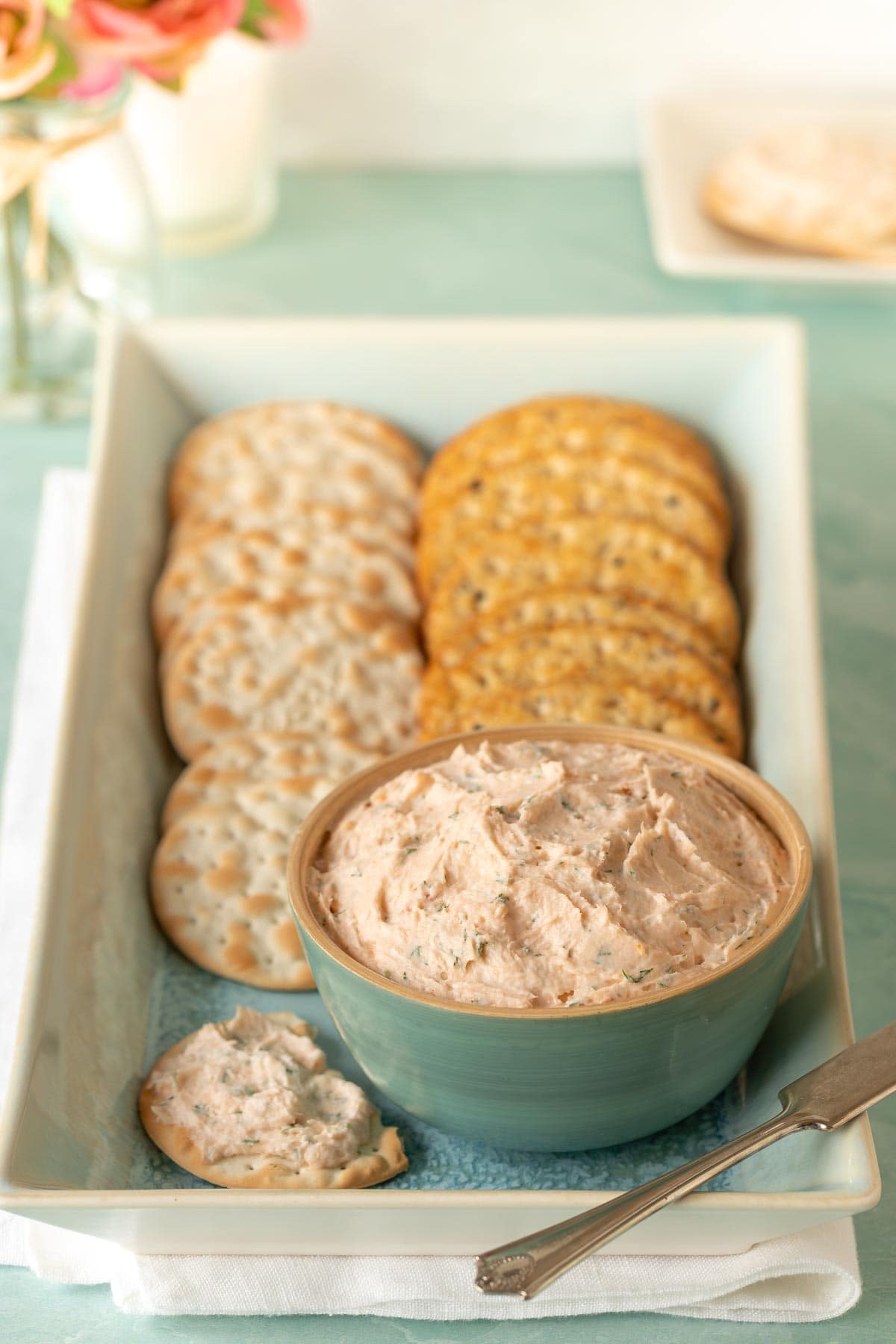 blue bowl holding Smoked Salmon Mouse on a platter that's also holding crackers