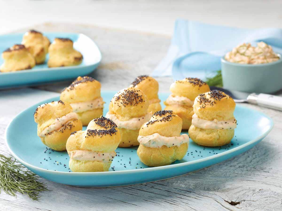 blue plate holding 6 poppy seed puffs stuffed with smoked salmon mousse
