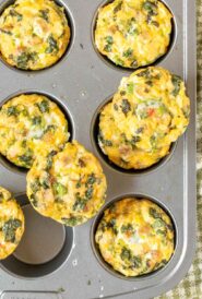 Overhead view of Sausage, Egg and Cheese Muffins in muffin pan, with 3 muffins sitting on top
