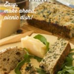 Wooden plate with sliced Sausage and Spinach Torte, alongside a wedge of cheese