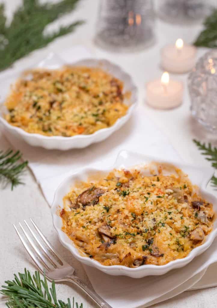 Two individual shelll dishes filled with seafood au gratin