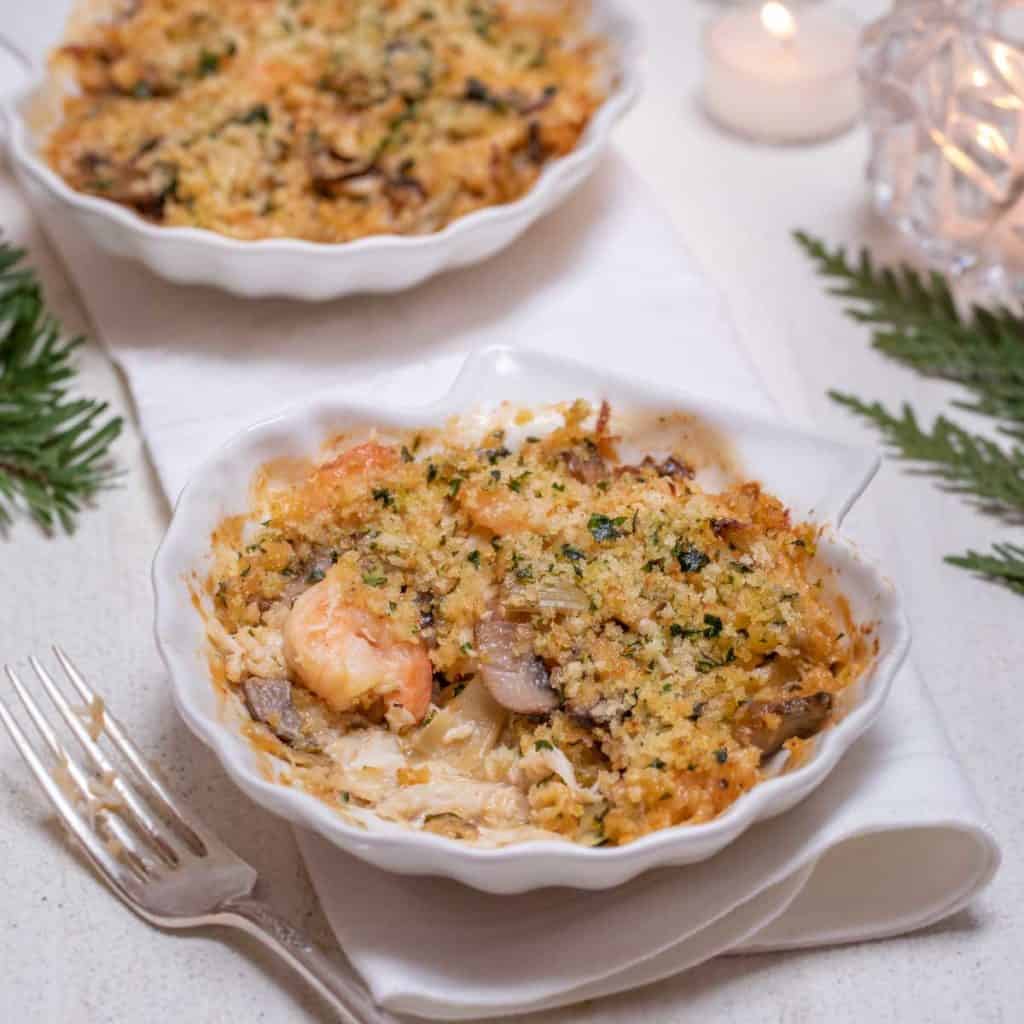 Shell shaped dish filled with an individual serving of Shrimp and Crab Au Gratin