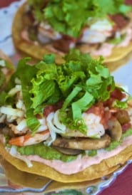 Sauteed shrimp and vegetables layered atop crispy corn tortillas with shredded cheese and lettuce