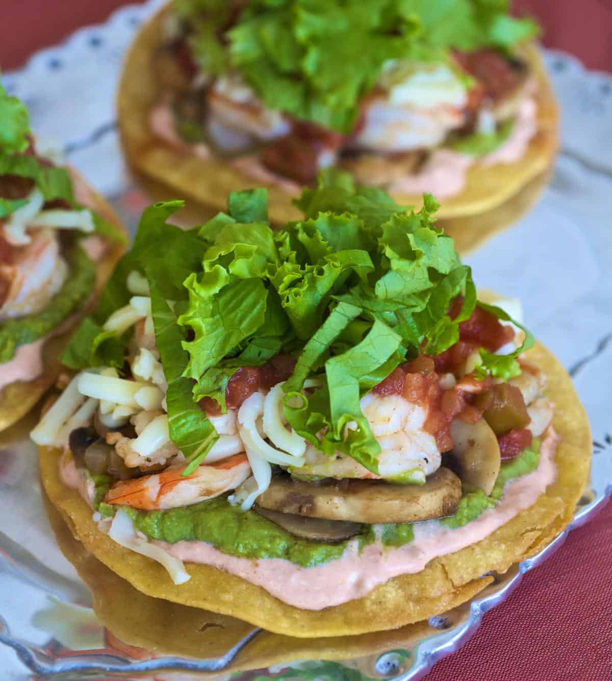 Sauteed shrimp and vegetables layered atop crispy corn tortillas with shredded cheese and lettuce