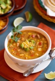 white bowl filled with Southwestern Chicken Soup with Avocado-Cheese Garnish