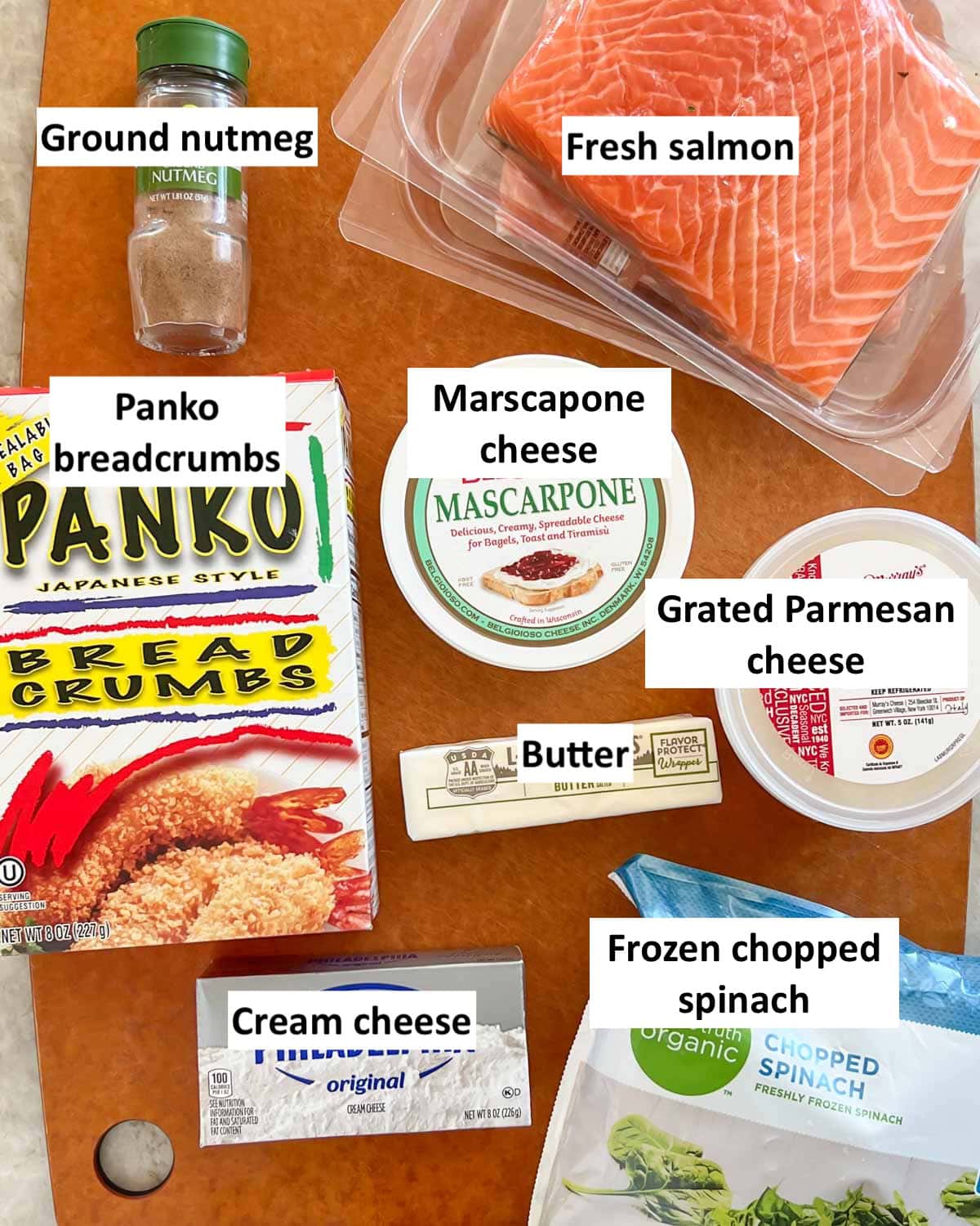 Cutting board holding all the ingredients in Spinach Stuffed Salmon, with labels