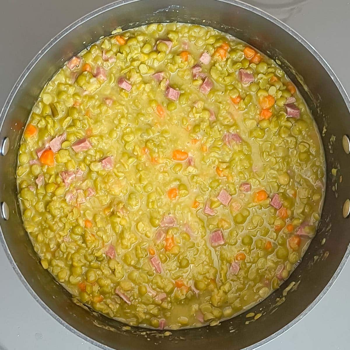 overhead view of split pea soup just after adding ham