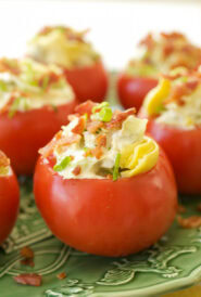 close up of 5 stuffed tomatoes sitting on a green platter