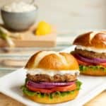 white platter with two Sundried Tomato Turkey Burgers with Lemon-Green Onion Sauce