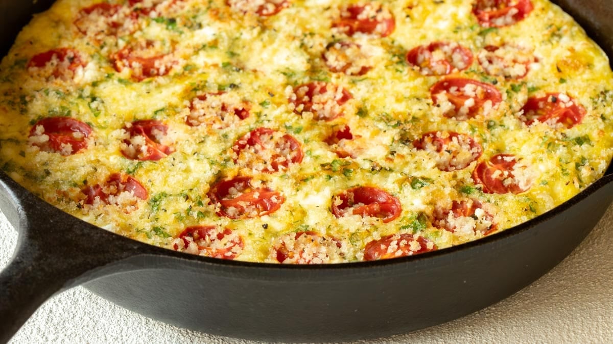 Close up of a cast iron skillet holding a Tomato Frittata with Feta