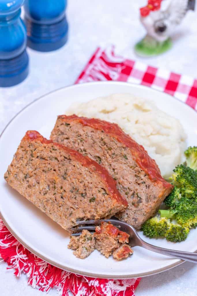 white plate holding two slices of Easy Turkey Meatloaf, mashed potatos and broccoli