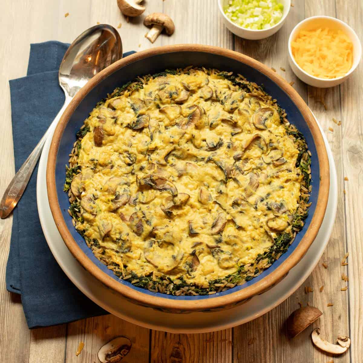 Blue pie dish filled with Turkey Mushroom Pie with Brown Rice-Spinach Crust