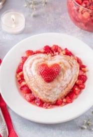 A round white plate holds a single serving of Valentine's Mini Cakes with Strawberry Almond Salsa
