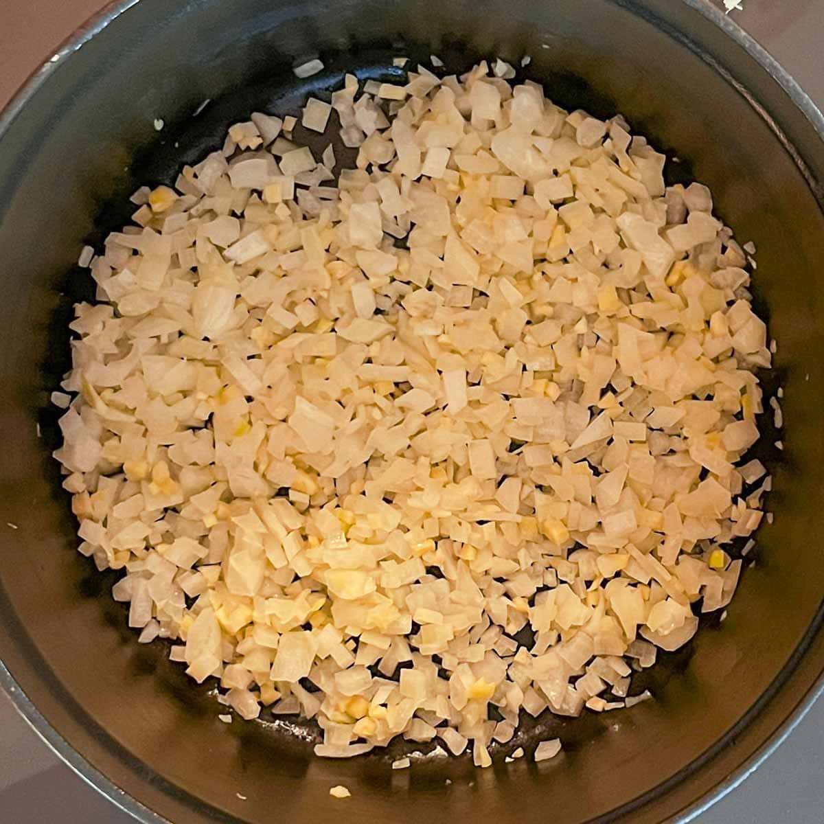 View of browning onions and ginger in oil for Mixed Vegetable curry