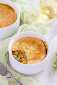 Small white dish holding one serving of Vegetarian Pot Pie with part of the crust removed to show filling