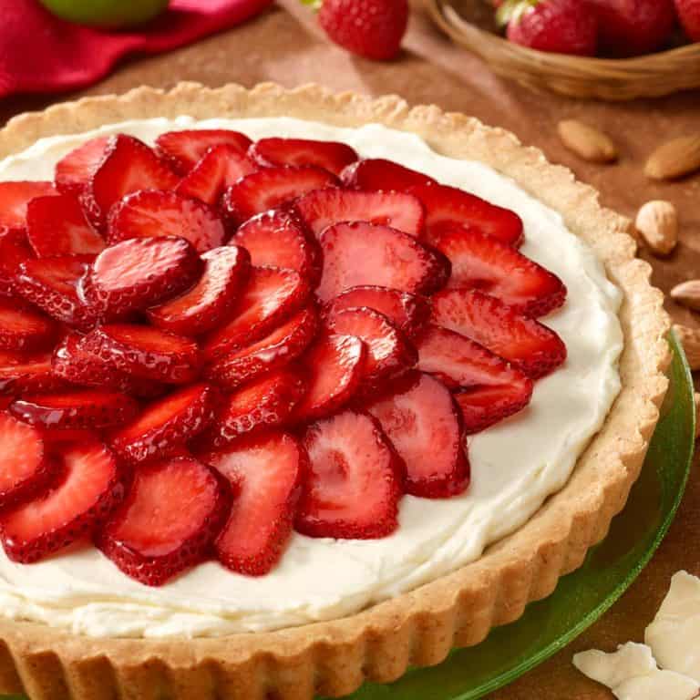 Round green plate with White Chocolate Lime Tart with Strawberries on top